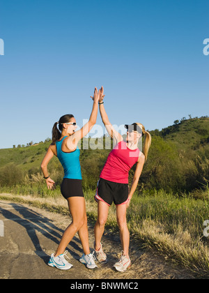 Two trail runners giving each other a high five Stock Photo