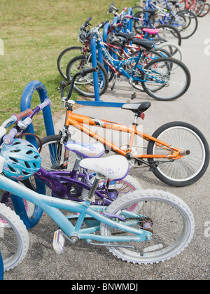 Row of children's bicycles locked up in school yard Stock Photo