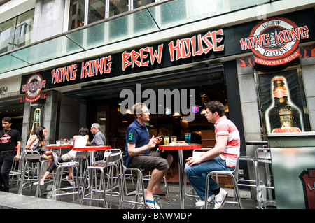 Friends enjoy a cold beer at the Hong Kong brew house located at the bustling Lan Kwai fong area in Central. Stock Photo