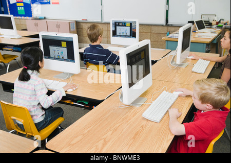 Children working at computers in classroom Stock Photo