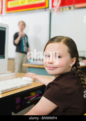 Elementary student sitting at desk in classroom Stock Photo