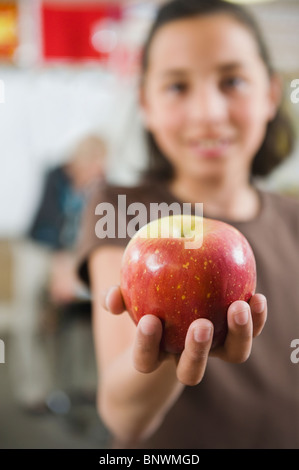 Elementary student holding an apple in her hand Stock Photo