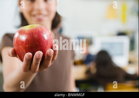 Elementary student holding an apple in her hand Stock Photo