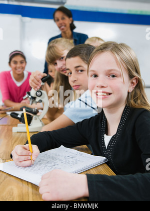 Teacher and elementary students looking at microscope Stock Photo