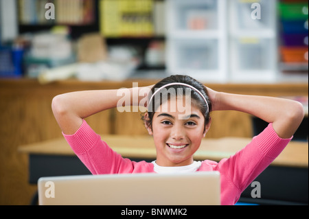 Elementary student relaxing at her desk Stock Photo