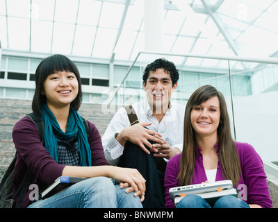 College students sitting on steps in front of library Stock Photo