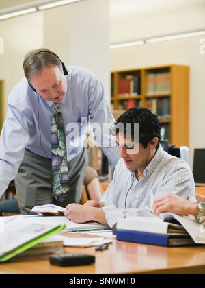College professor helping college student in library Stock Photo