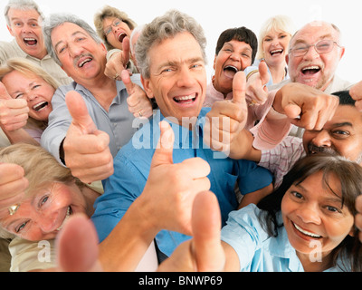 A group of people giving the thumbs up sign Stock Photo