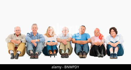 A group of people sitting on the floor in a row Stock Photo