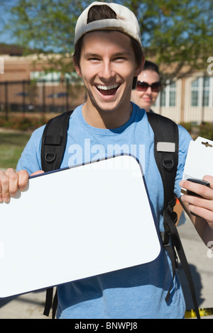 Happy teenage student holding blank whiteboard Stock Photo