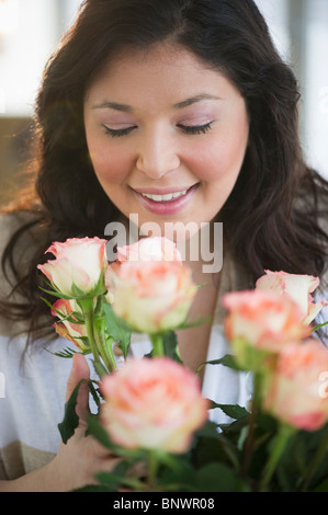 A young woman smells the pink roses in her garden Stock Photo - Alamy