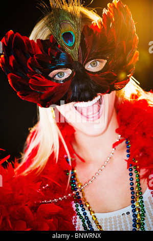 Person wearing a mardi grass mask and beads Stock Photo