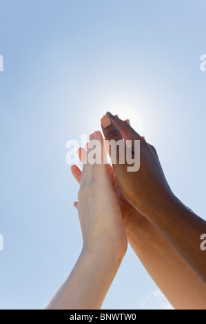 Hands held up in front of sunshine