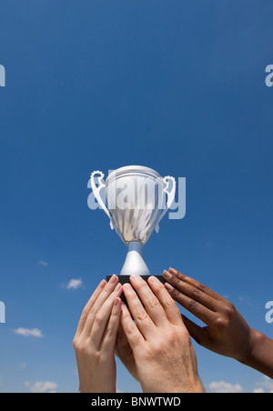 Hands holding trophy in the air Stock Photo