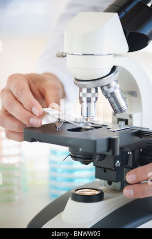 Hands on a microscope Stock Photo - Alamy