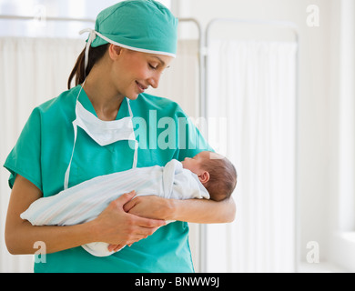 Nurse holding swaddled baby Stock Photo