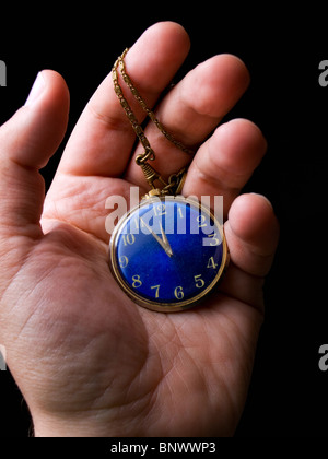 Old pocket watch in hand on a black background Stock Photo
