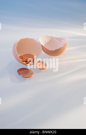 Pennies in a cracked egg shell Stock Photo