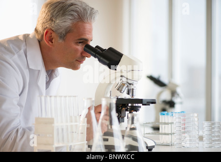 Researcher looking through microscope Stock Photo