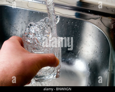 Moment during the filling of water in a glass... Stock Photo