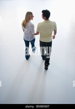 Happy couple walking hand in hand Stock Photo