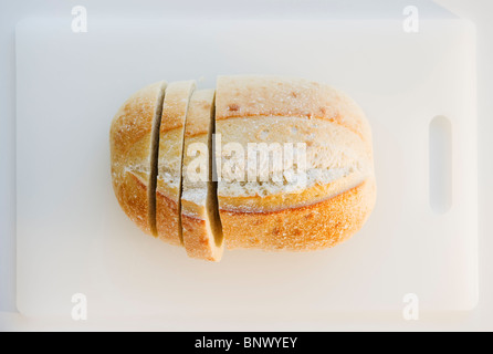 Freshly sliced bread on cutting board Stock Photo