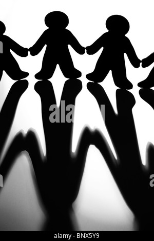 Black And White Image Of Silhouetted Figures Joining Hands To Illustrate Concept Of Support And Collaboration Stock Photo