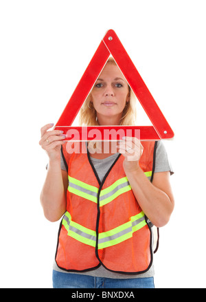 Woman in safety vest holding foldaway reflective road hazard warning triangle over white background Stock Photo