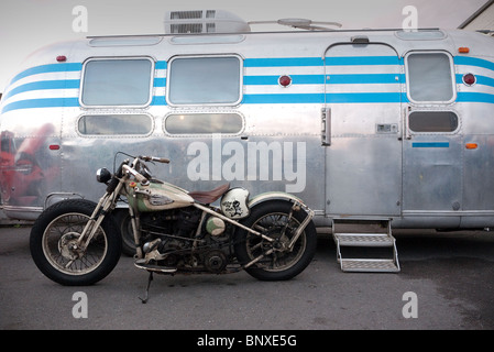 Old Harley Davidson Motorcycle parked by an Airstream caravan Ace Cafe London UK Stock Photo