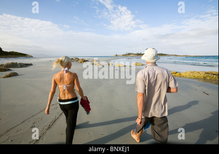 A couple walk along Redbill Beach. Bicheno, Tasmania, AUSTRALIA Stock Photo