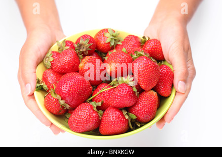 Crockery with strawberries in woman hands. Isolated on a white background. Stock Photo