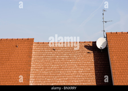 Satellite dish and antenna mounted to rooftop Stock Photo