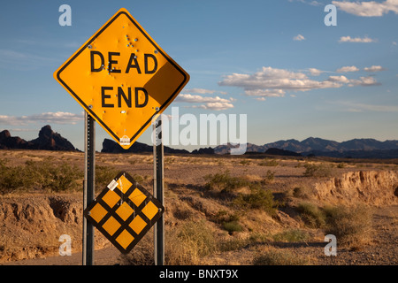 Dead End highway sign in the desert in Arizona USA with shotgun bullet holes damage Stock Photo