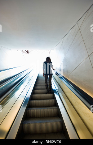 Riding escalator, rear view Stock Photo