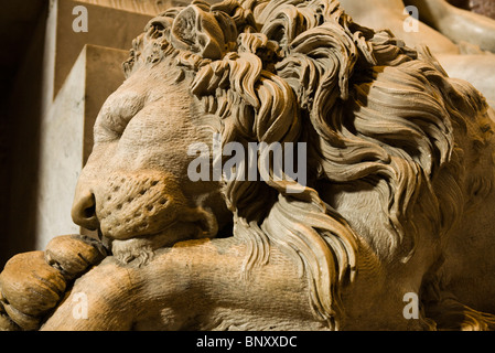 Statue of sleeping lion flanking Monument to Clement XIII, St. Peter's Basilica, Rome, Italy Stock Photo