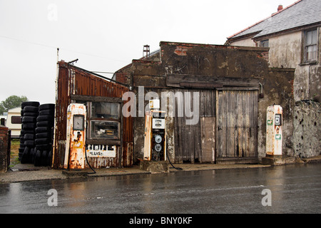 Petrol pumps outside an old fashioned, derelict garage, North Wales, UK Stock Photo