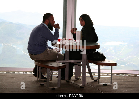 Couple drinking at Mount Snowdon summit cafe, Snowdonia National Park, North Wales, UK Stock Photo