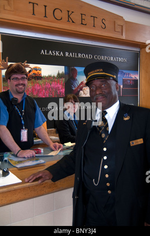 Conductor greets guest at the Alaska Railroad ticketing area Stock Photo