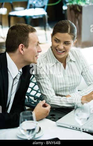Woman looking flirtatiously at companion in restaurant Stock Photo