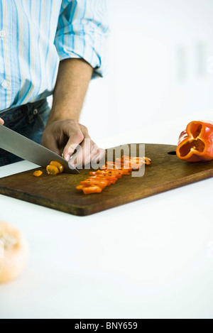 Slicing fresh red bell pepper on cutting board Stock Photo