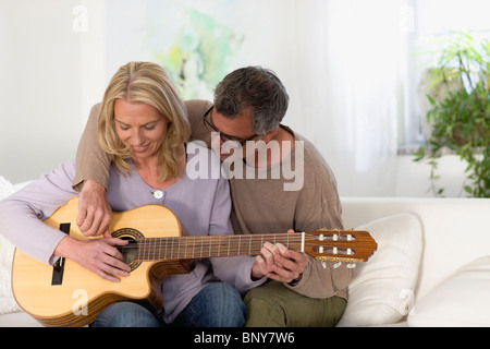 Man and woman strumming guitar Stock Photo