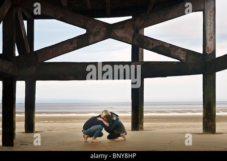 Couple sheltering on beach Stock Photo