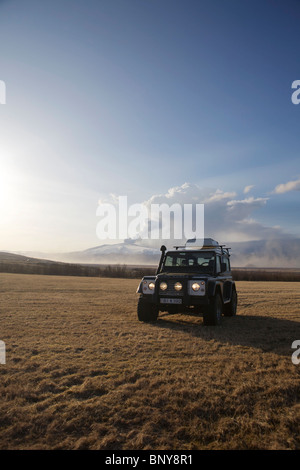 Land Rover Defender 90 300TDI in front of Eyjafjallajokull Volcan erupting in the background Stock Photo