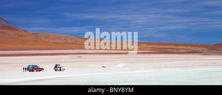 Panoramic image of 2 4WD vehicles stopping at a lake in the southern Bolivian desert Stock Photo
