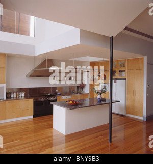 Wooden flooring in large modern kitchen with granite-topped island unit Stock Photo