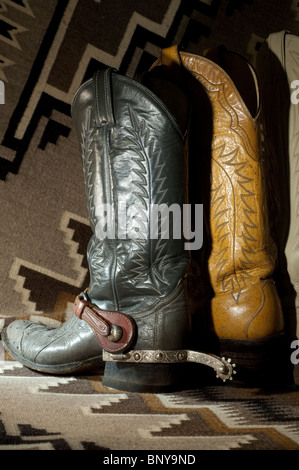 Leather cowboy boots, (gray pair, with silver spurs, made of ostrich skin) on Navajo Two Gray Hills Indian blanket. PR Stock Photo