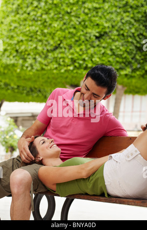 Young romantic couple on a bench in park Stock Photo - Alamy