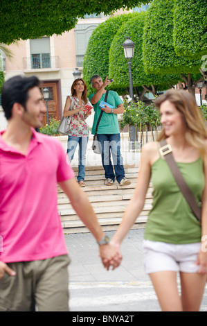 Couple holding hands crossing street Stock Photo