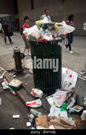 An overflowing trash can in the New York neighborhood of Chelsea on Sunday, August 1, 2010. (© Frances M. Roberts) Stock Photo