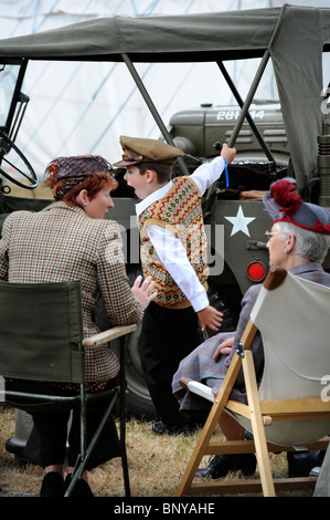 A boy appears bored in a US themed section of the Battle of Britain village at The Royal International Air Tattoo at RAF Fairfor Stock Photo